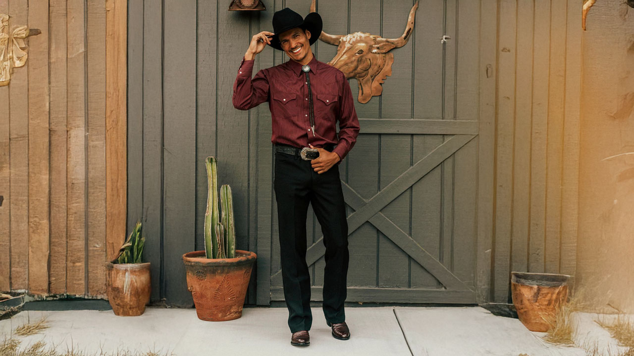A man wearing a pair of Signature Series boots, standing in front of a green barn.